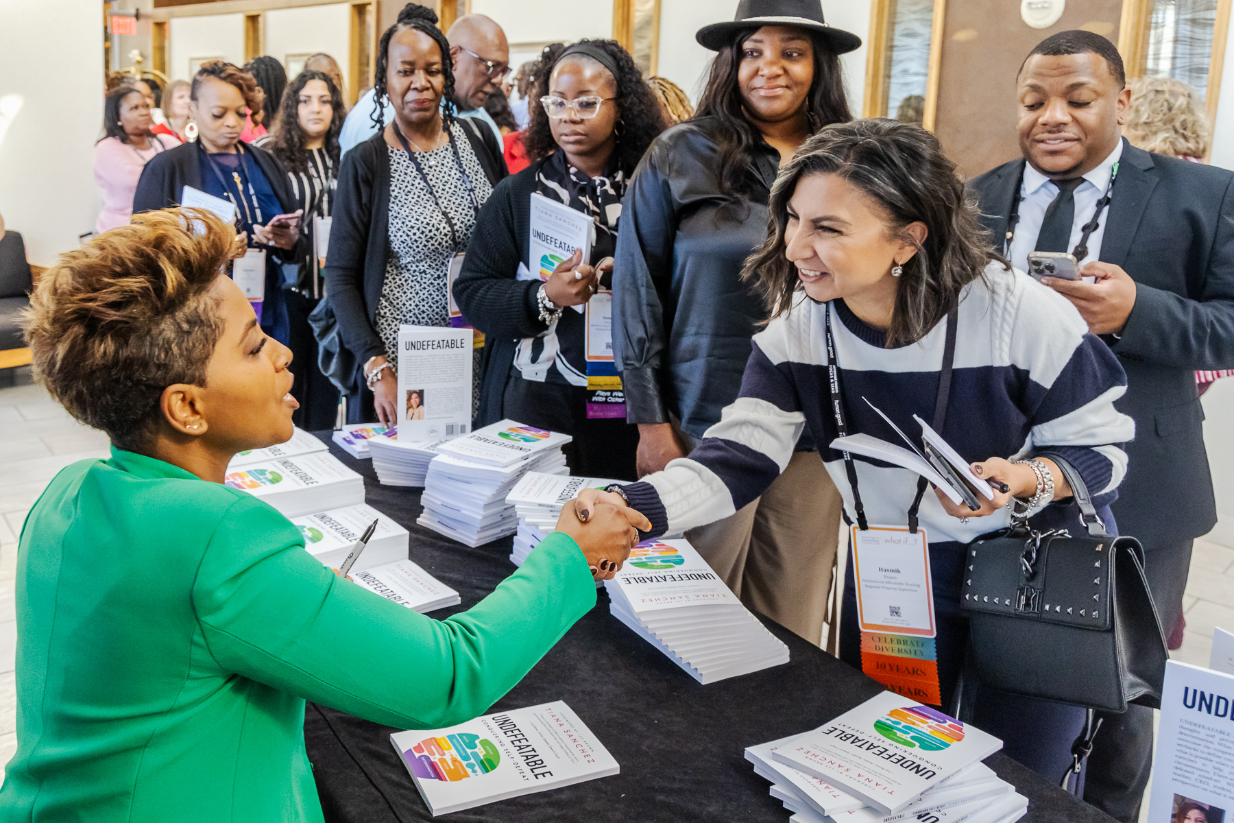 Tiana Sanchez signing copies of her books and greeting readers at an event
